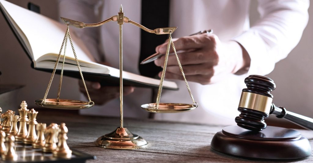 Gavel on wooden table and Lawyer or Judge working with agreement in Courtroom theme